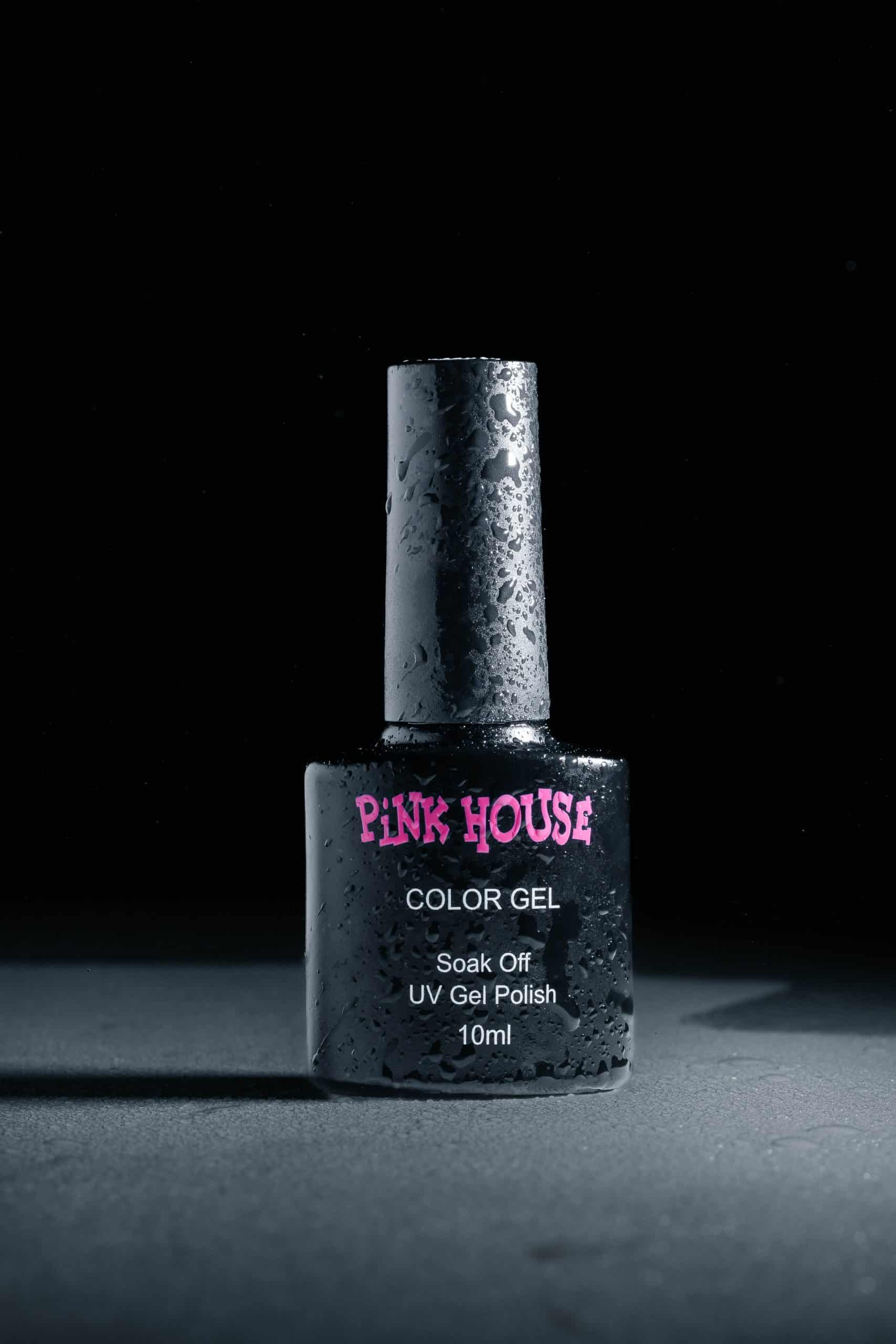 Close-up of a UV gel nail polish bottle with droplets on it