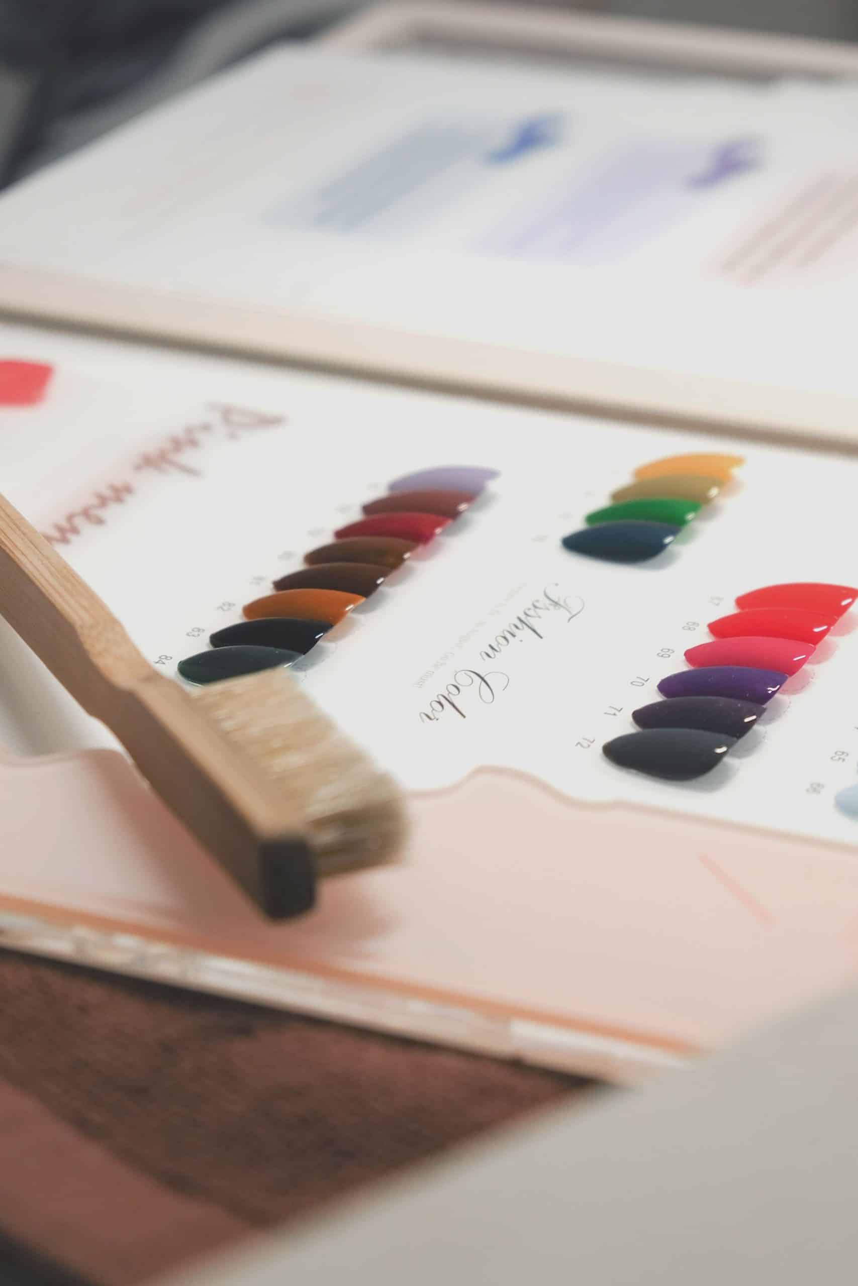 Set of colorful pre-shaped nail tips laid out by size before being glued onto natural nails