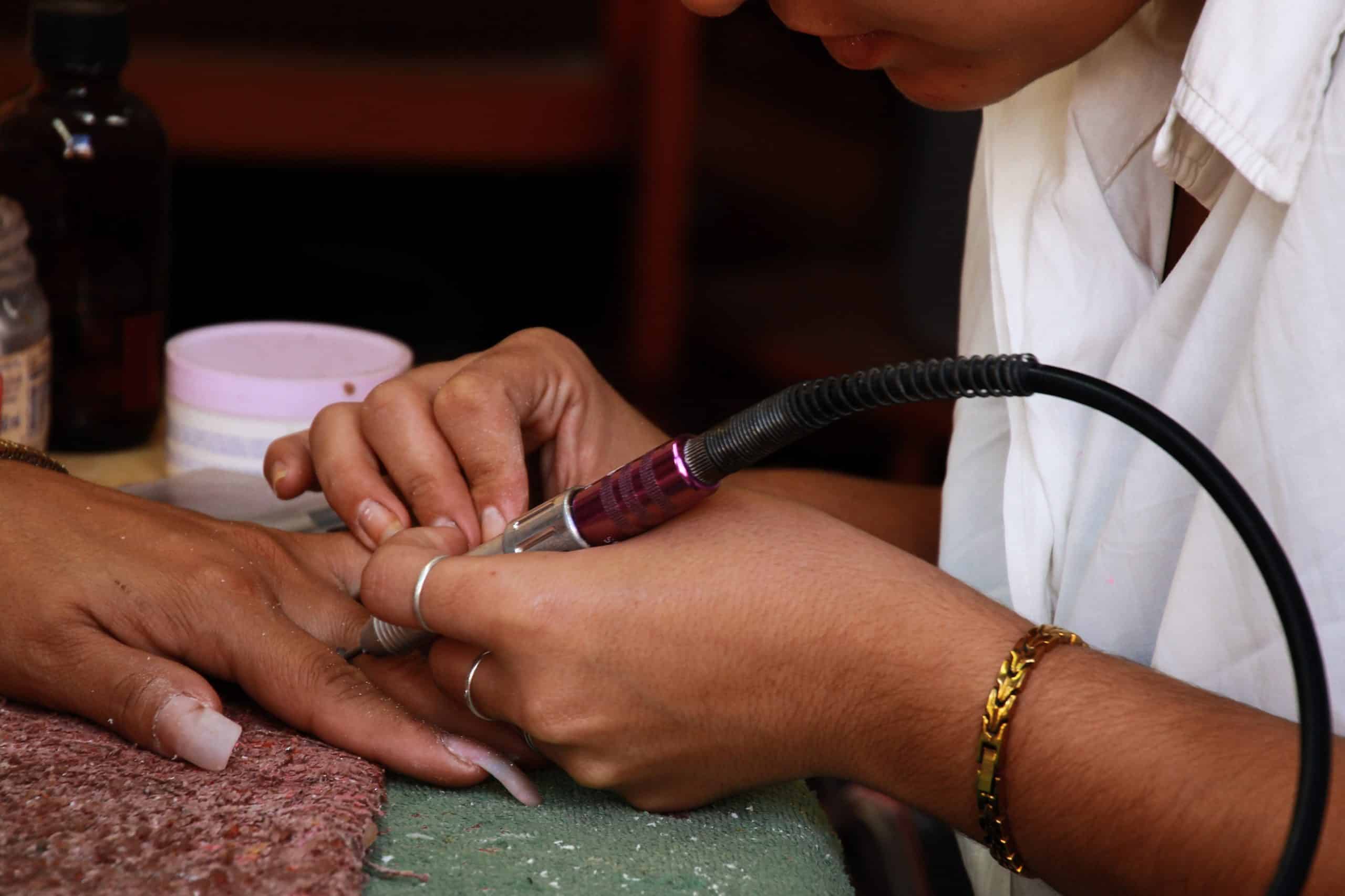 Professional manicure showing precise nail work during a fill