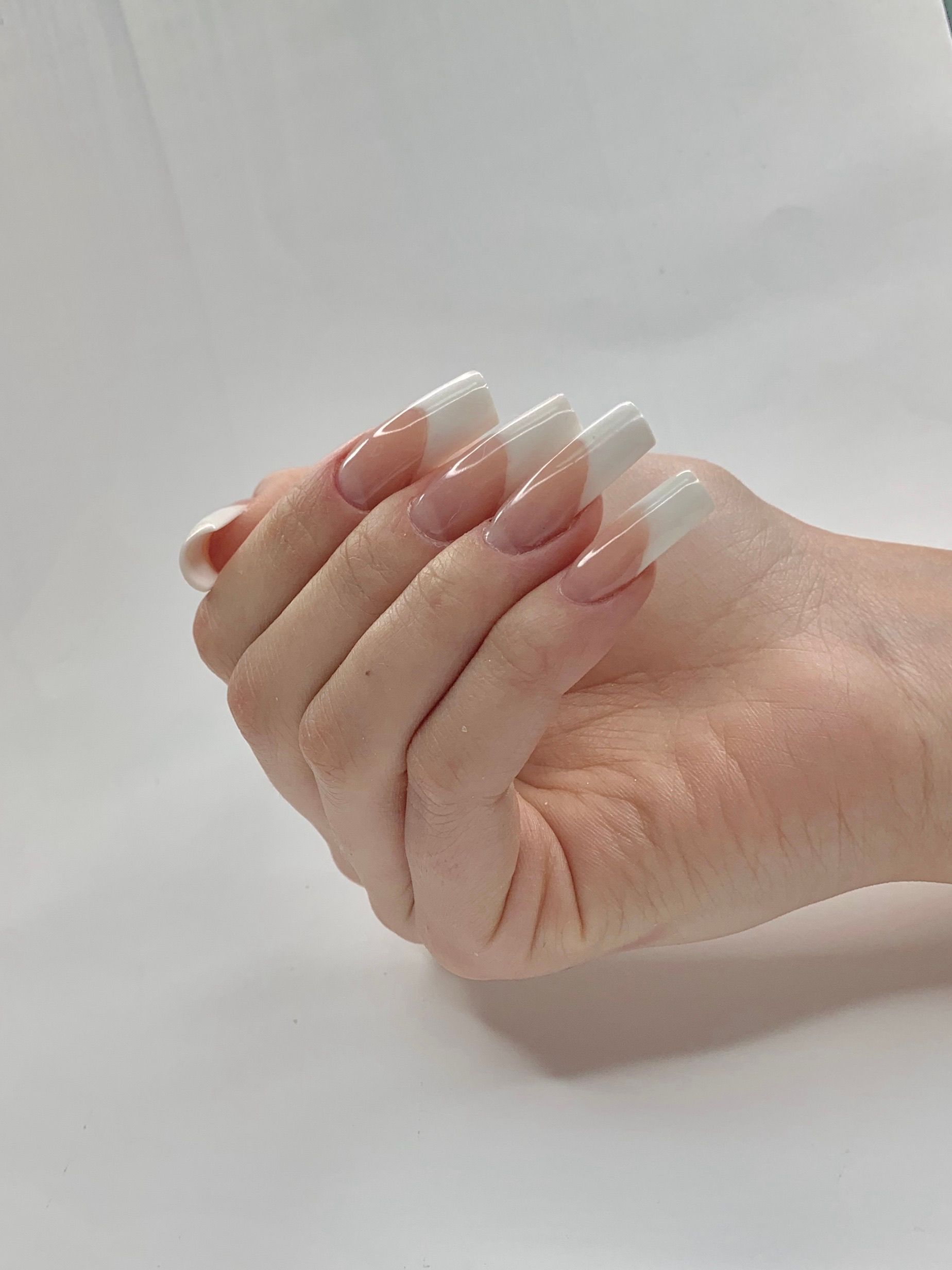 Close-up of a manicured hand with a classic gel tip