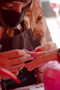 Nail technician applying a pre-shaped tip extension to a client's nail