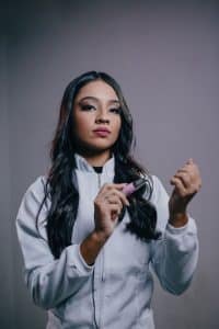 Nail technician holding an electric nail drill with interchangeable bits
