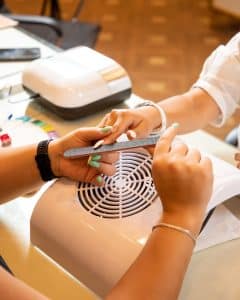 Nail technician performing a nail extension service on a client