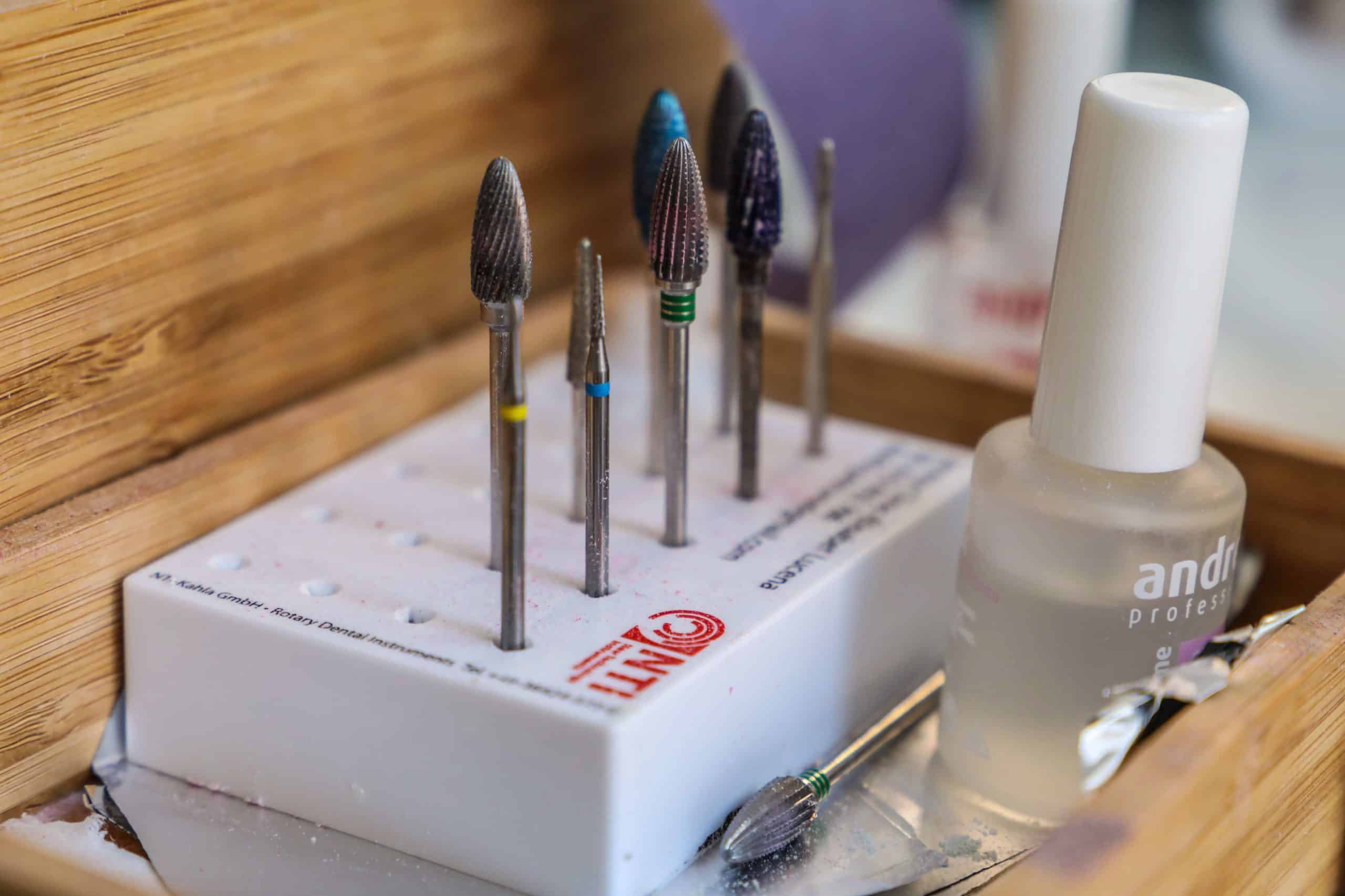 Close-up of assorted manicure drill bits arranged in a case