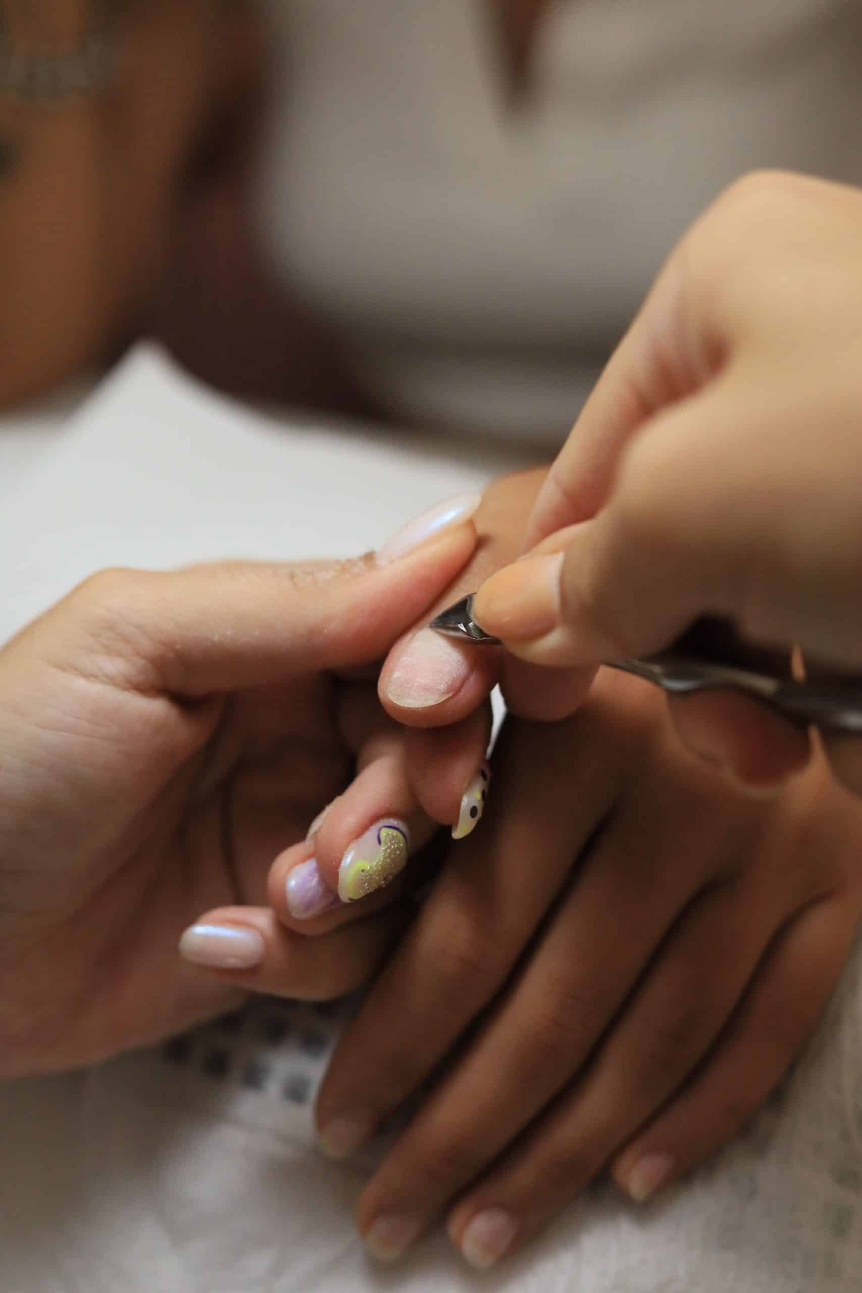 Trimming cuticles with nippers during a professional manicure