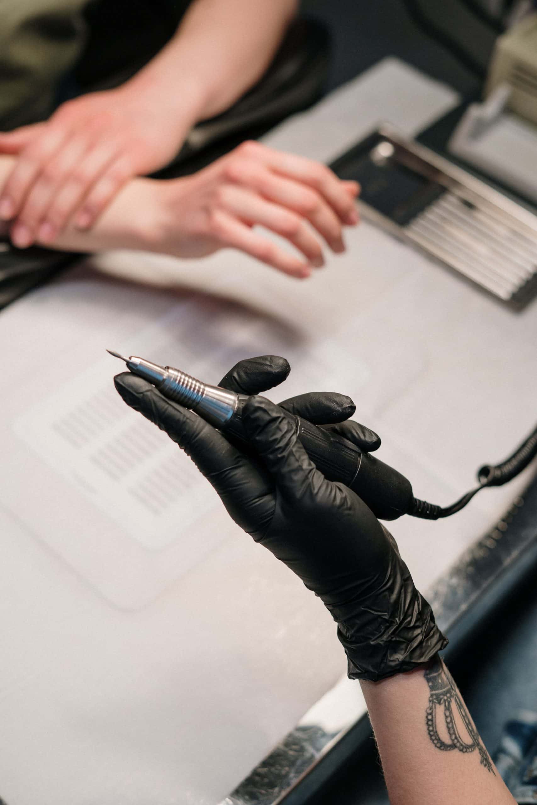 Nail technician using an e-file bit on a client's nails during a manicure