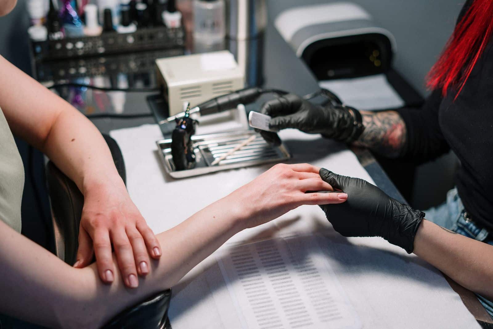 Nail technician carefully handling a client's hand during nail prep
