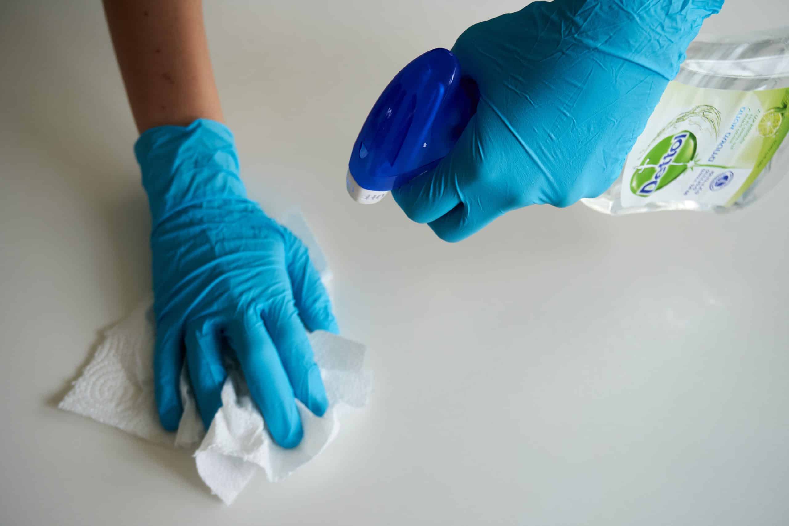 Person wearing rubber gloves while cleaning to protect a fresh gel manicure