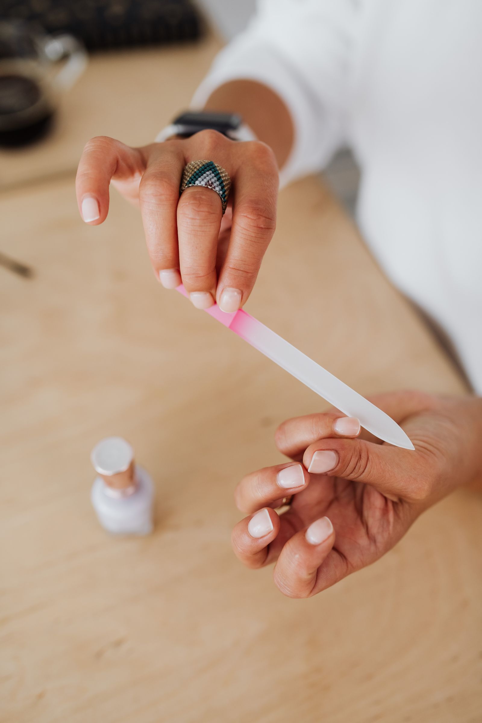 Close-up of a hand filing nails during a home manicure with a nail buffer
