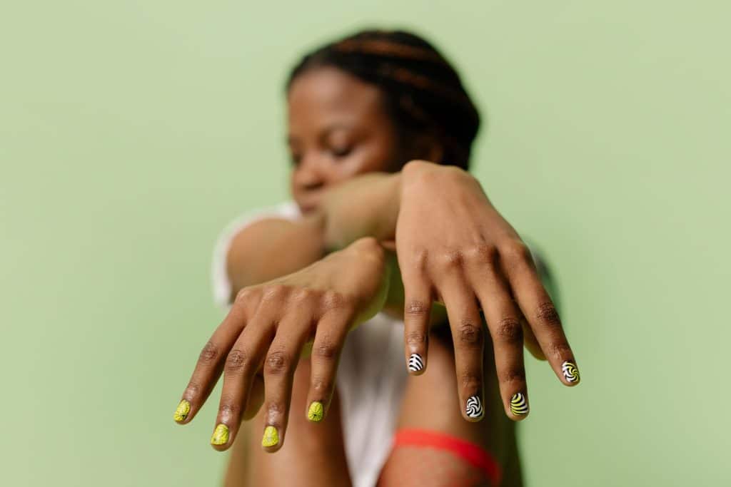 Manicure being performed on the hands of a seated woman