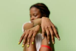 Manicure being performed on the hands of a seated woman