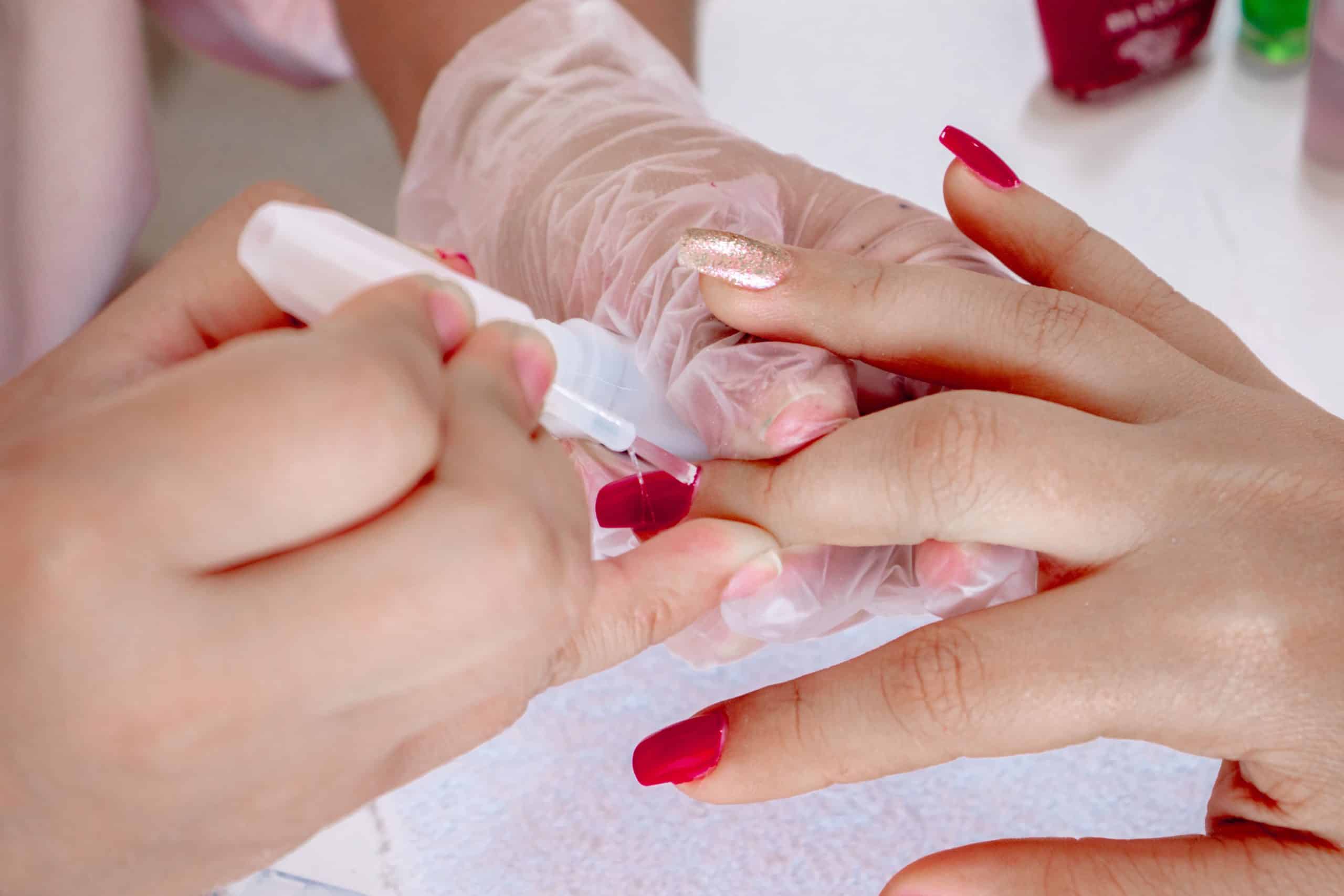 Applying gel color to a fingernail during a manicure