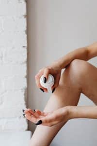 Woman holding a white product bottle above her palm