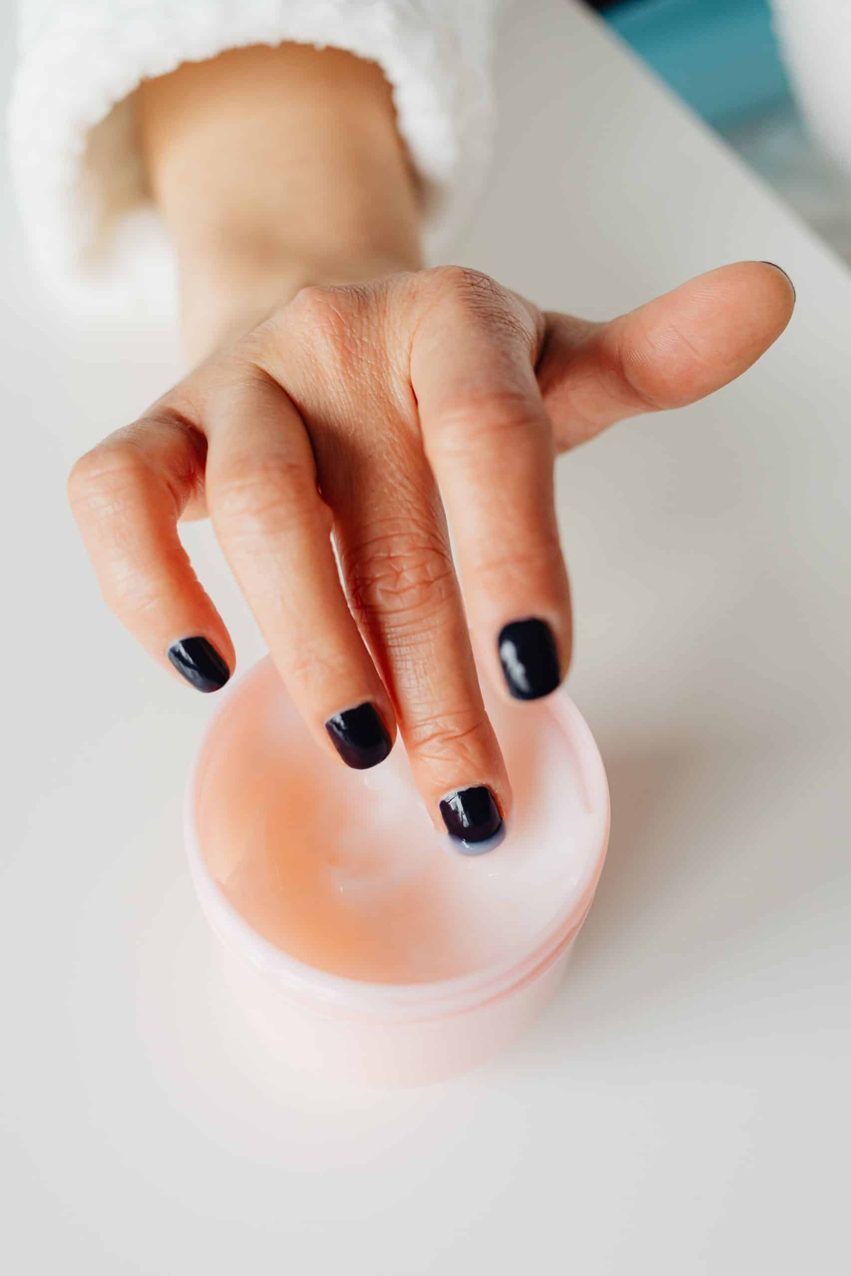 Hand applying a liquid nail prep product before polish