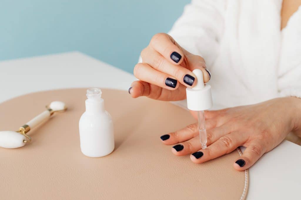 Woman applying cuticle oil to her nails