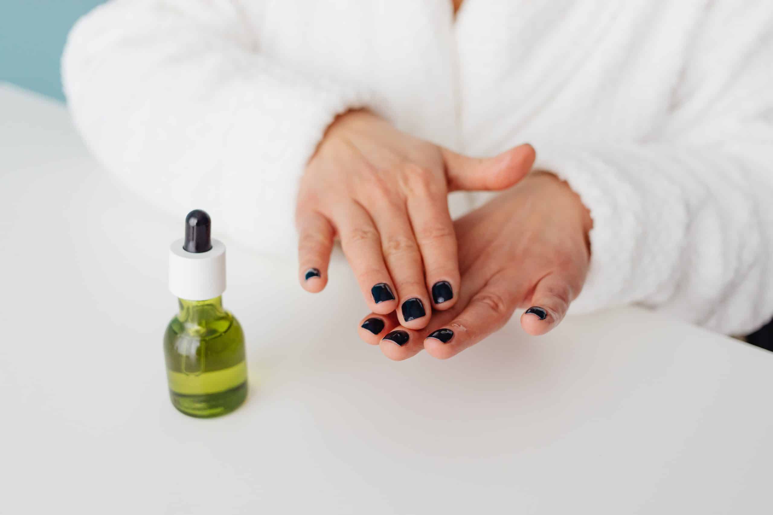 Close-up of hands applying moisturizing oil after acetone exposure