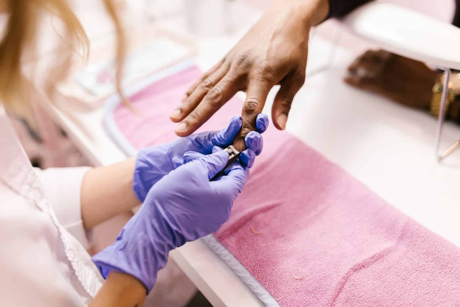 Close-up of a manicure in progress with gloves and nail care tools
