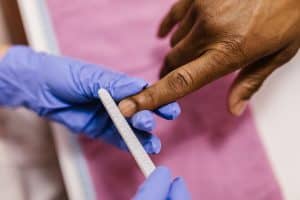 Close-up of a hand having its gel nails checked, illustrating how to inspect a nail for lifting after a week