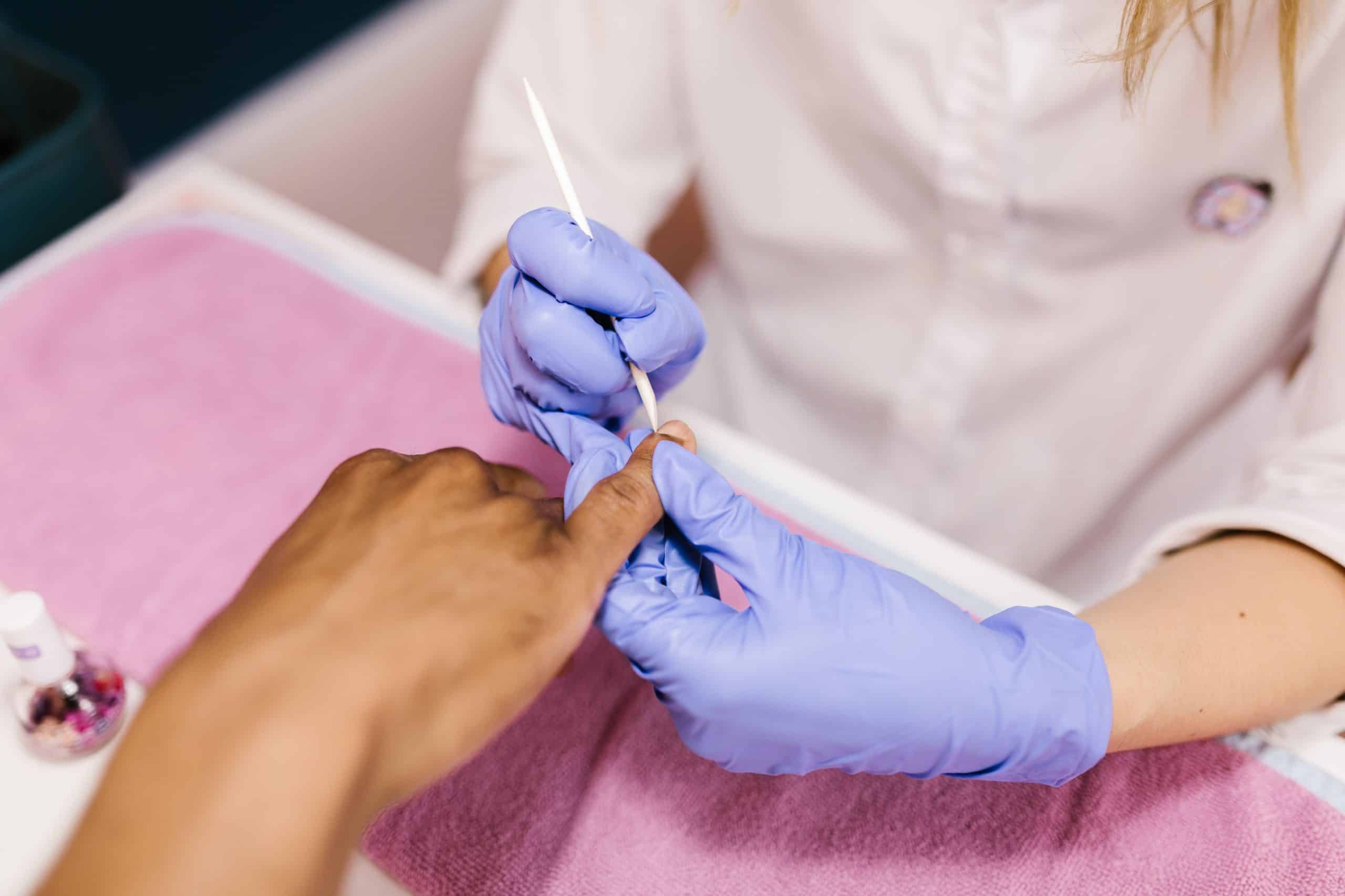 Manicurist performing cuticle care during a manicure