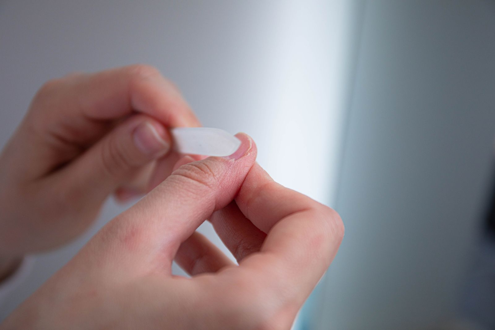 Hands using a nail file to prep the nail plate before builder gel