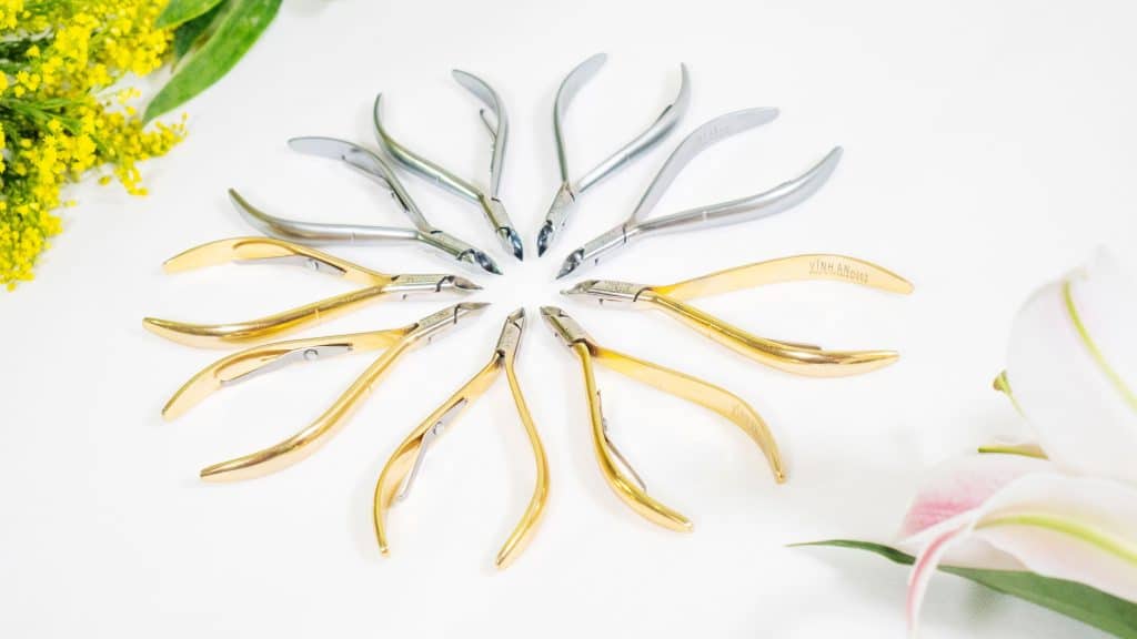 Stainless steel cuticle nippers arranged in a studio still life